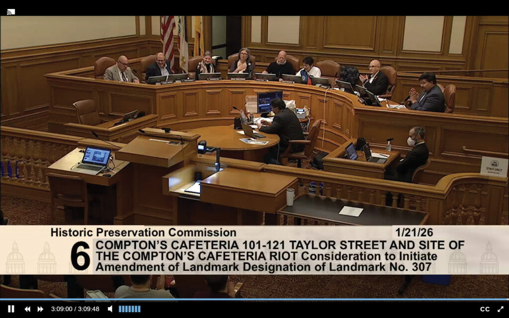 Wide view of the San Francisco Historic Preservation Commission seated at the curved dais inside City Hall during a public hearing on expanding landmark protections for the Compton’s Cafeteria Riots site, with commissioners, staff, and members of the public visible. Photo: Screenshot of the San Francisco Historic Preservation Commission via SFGov TV